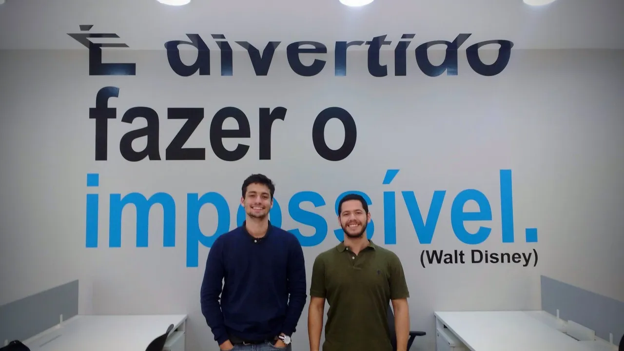 Eu e Gabriel numa incubação na UFRJ. A frase ao fundo resume a jornada.