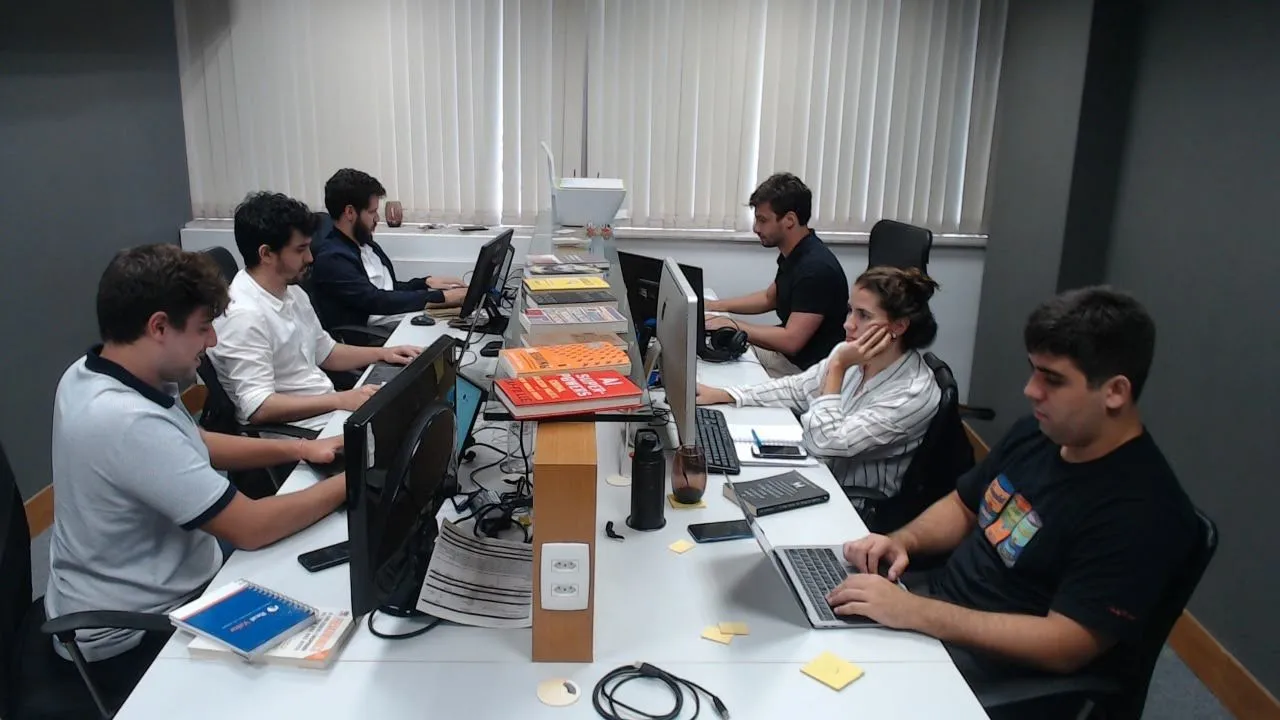 Equipe trabalhando junto no escritório (um dos funcionários era remoto)